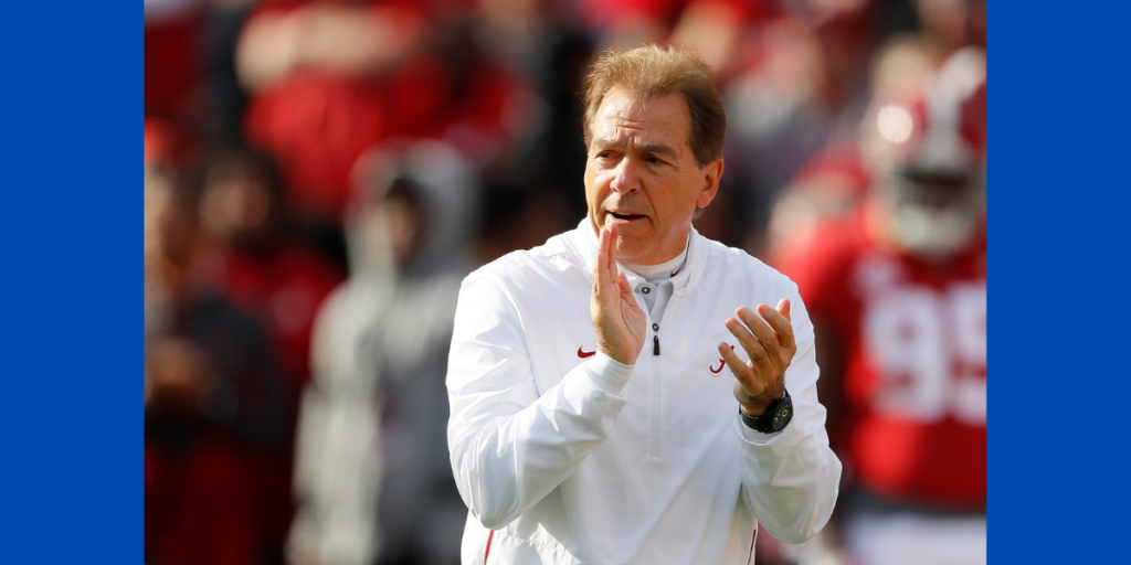 Nick Saban claps during a football game