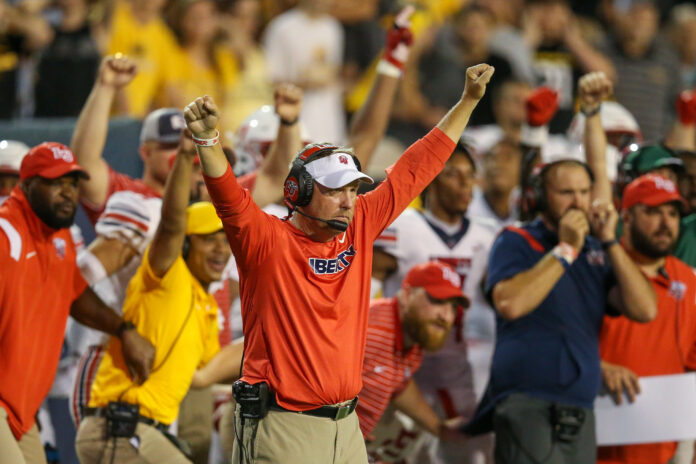 Hugh Freeze raises hands in celebration during a Liberty football game