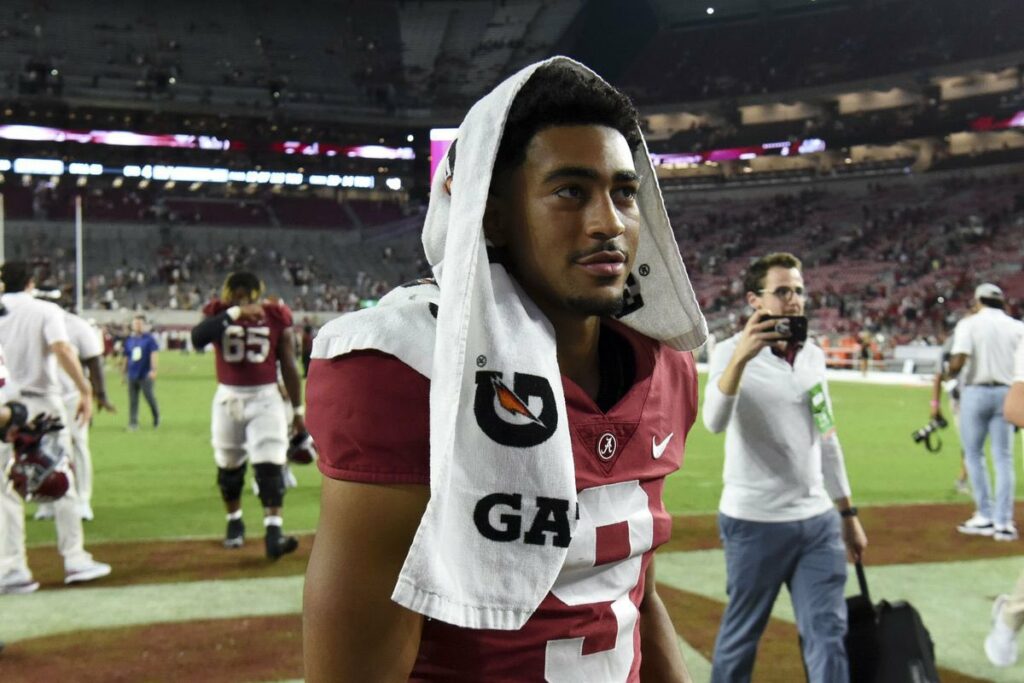 Bryce Young leaves the field with a Gatorade towel over his head